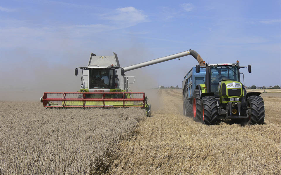 Claas harvester and tractor in field