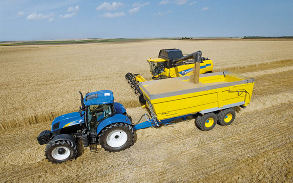 New Holland tractor and harvester in the field