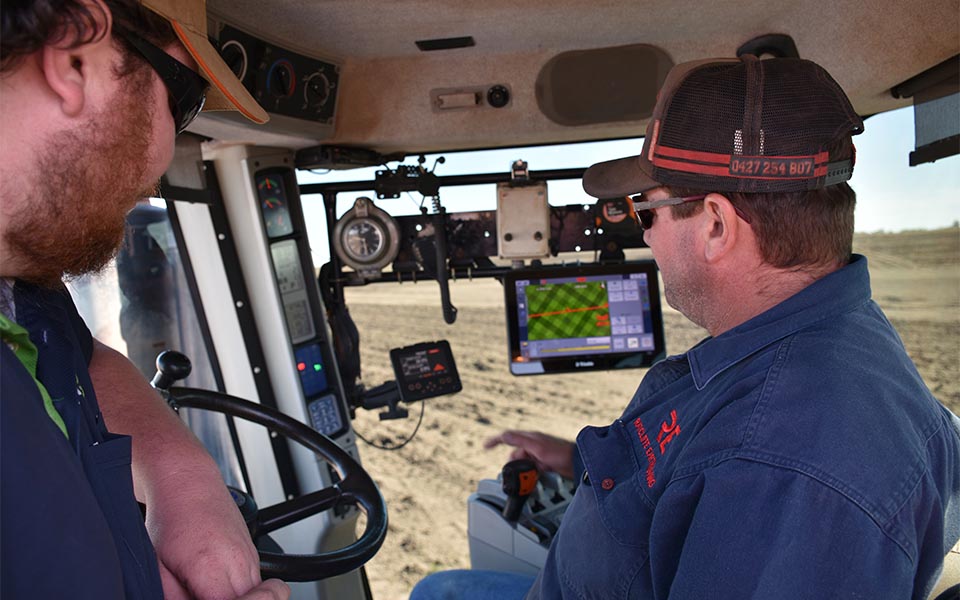 Vantage rep helping farmer with Trimble system inside tractor cab