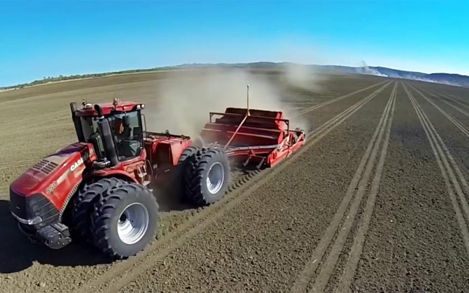 Red Case tractor pulling red scraper